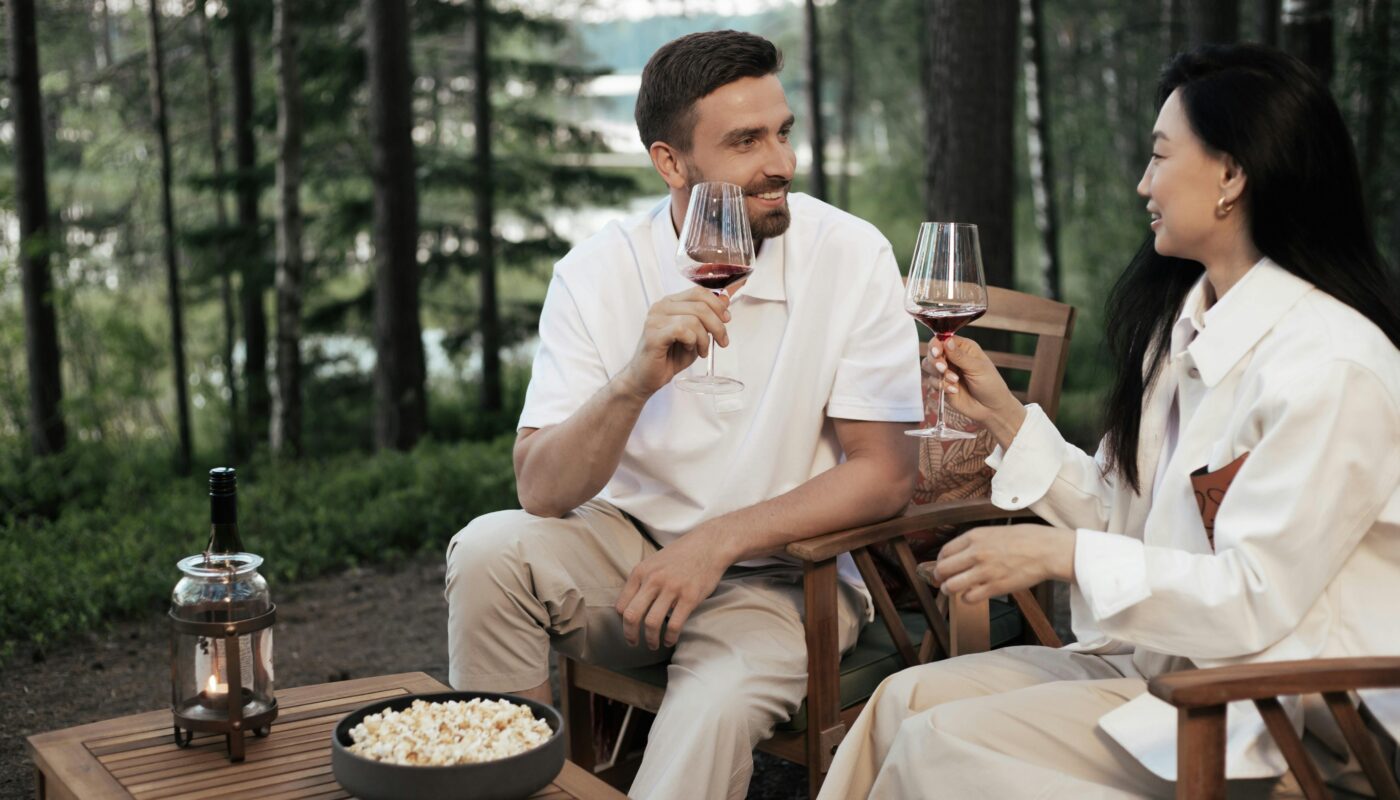 https://www.pexels.com/photo/a-couple-sitting-on-wooden-chairs-holding-glasses-of-wine-8845115/